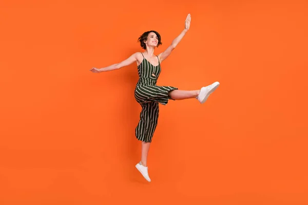 Foto lateral de perfil de tamanho completo de menina animada feliz acrobacias sorriso positivo isolado sobre fundo cor de laranja — Fotografia de Stock