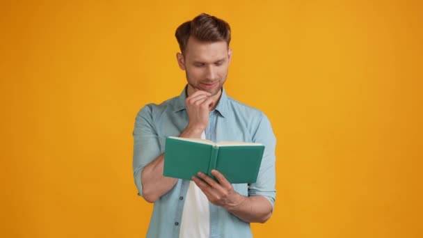 Cheerful clever thoughtful guy read book imagine ideas look empty space — Stock Video