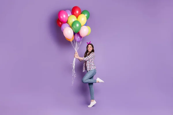Πλήρες μήκος σώματος φωτογραφία μέγεθος χαρούμενο χαρούμενο χαρούμενο κορίτσι κρατώντας πολύχρωμα μπαλόνια γιορτάζει τα γενέθλια απομονωμένη ζωντανή violetcolor φόντο — Φωτογραφία Αρχείου