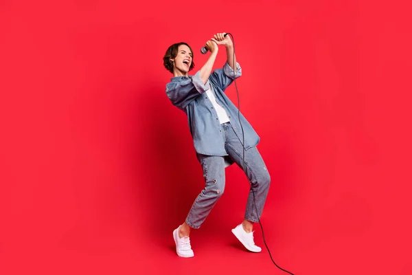 Teljes test profil oldal fotó fiatal nő boldog pozitív mosoly énekel mikrofon zene szerető elszigetelt piros szín háttér — Stock Fotó