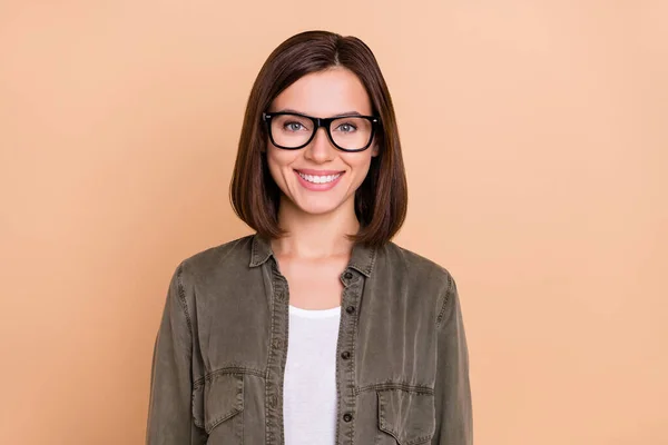 正の魅力的な女性の光沢のある歯の笑顔を着用アイウェアカーキシャツ孤立ベージュ色の背景 — ストック写真