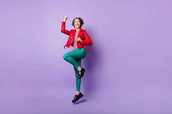 Profil pleine grandeur photo de côté de la jeune fille sourire heureux se réjouir victoire saut poings mains isolées sur fond de couleur pourpre — Photo