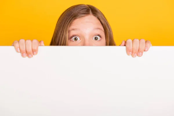 Portret van school persoon ogen gluren achter grote lege ruimte muur geïsoleerd op gele kleur achtergrond — Stockfoto