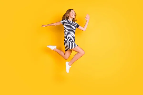 Retrato de perfil em tamanho completo de menina alegre animada olhar espaço vazio onda de mão isolado no fundo de cor amarela — Fotografia de Stock