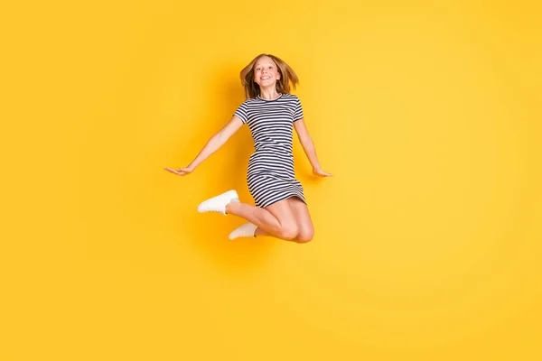 Full body foto van zorgeloze vriendelijke leerling springen hoge tanden glimlach kijken camera geïsoleerd op gele kleur achtergrond — Stockfoto