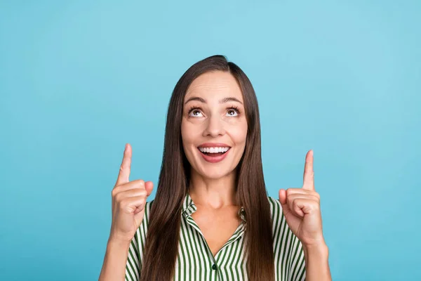 Foto van vrolijke jonge dame look geven vingers lege ruimte raden suggereren advertenties geïsoleerd over blauwe kleur achtergrond — Stockfoto