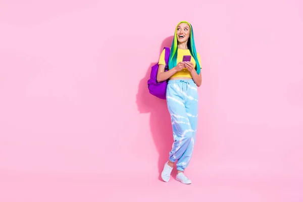 Фотографія повного розміру щасливої здивованої дівчини виглядає як копія простору піти до шкільного коледжу сумочки ізольовані на рожевому кольоровому фоні — стокове фото