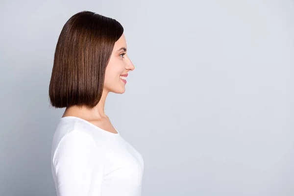 Профиль фото оптимистичной брюнетки юная леди смотреть пустое пространство носить белый пуловер изолированы на сером фоне цвета — стоковое фото