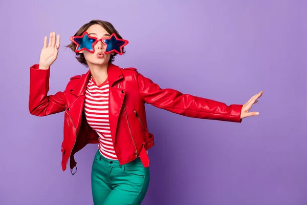 Фото молодой привлекательной девушки весело провести время наслаждаться танцем носить солнцезащитные очки изолированы на фиолетовый цвет фона — стоковое фото