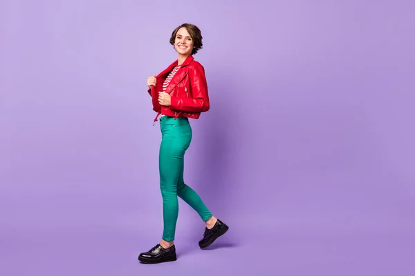 Foto de perfil de tamanho completo de senhora bonita andando braços toque jaqueta dente sorriso isolado no fundo cor violeta — Fotografia de Stock