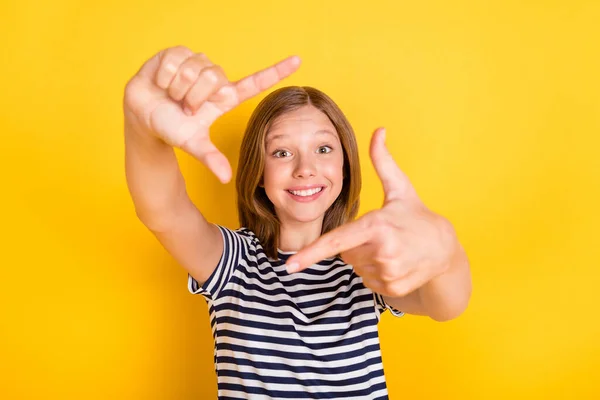Retrato de escola positiva menina braços dedos fazer quadro figura dente sorriso isolado no fundo de cor amarela — Fotografia de Stock
