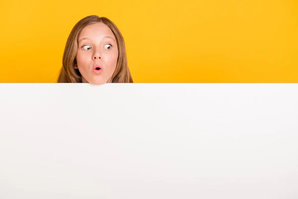 Portret van een onder de indruk school persoon open mond kijken geïnteresseerd lege ruimte geïsoleerd op gele kleur achtergrond — Stockfoto