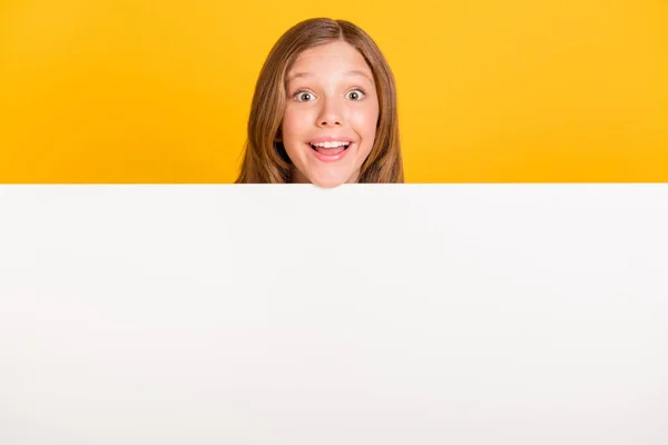 Foto van verbaasd vrolijke leerling hoofd boven lege ruimte muur tand glimlach geïsoleerd op gele kleur achtergrond — Stockfoto