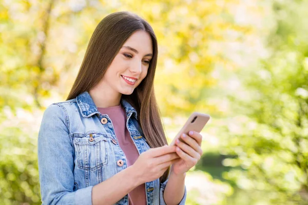 Retrato de atraente focada menina alegre passar tempo usando dispositivo blogging ao ar livre passeando ao ar livre — Fotografia de Stock