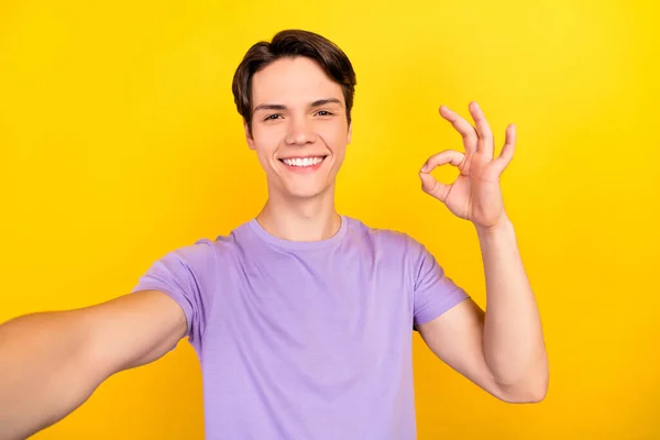 Autorretrato de atractivo chico alegre confiado que muestra anuncio de signo de ok aislado sobre fondo de color amarillo brillante — Foto de Stock