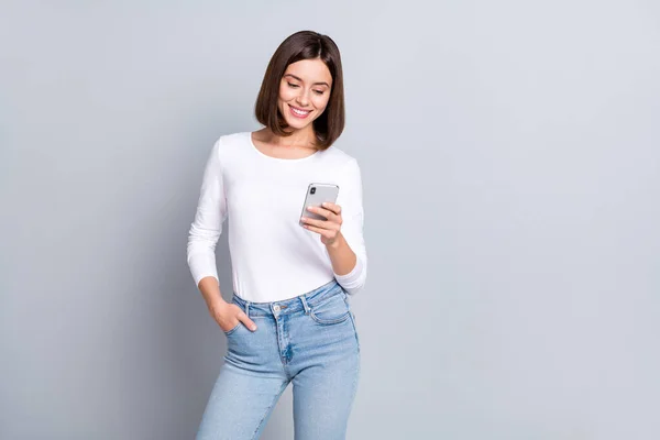 Foto di dolce bob acconciatura millenaria signora sguardo telefono usura camicia jeans isolato su sfondo di colore grigio — Foto Stock