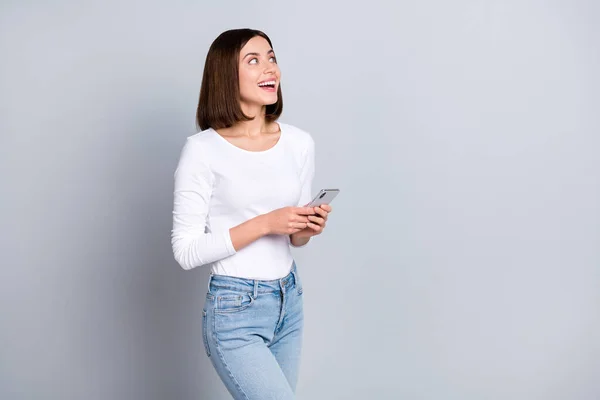 Foto del peinado bob impresionado Milenial lady hold phone look promo wear jersey jeans aislado sobre fondo de color gris — Foto de Stock