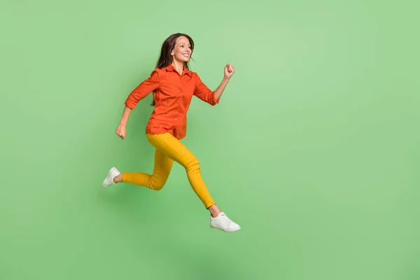 Fénykép izgatott édes érett hölgy öltözött piros ing ugrás magasan futó gyors üres tér mosolygós elszigetelt zöld szín háttér — Stock Fotó