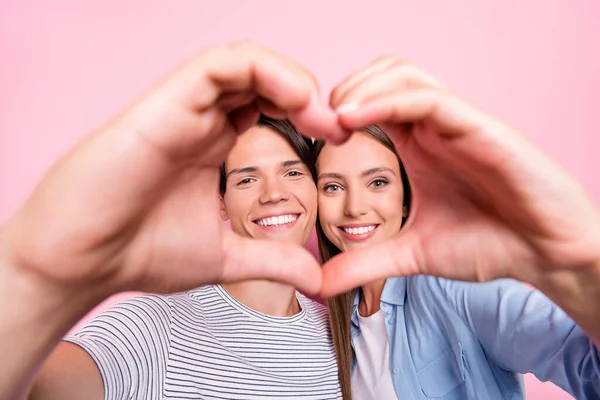 Фото блестящей веселой молодой пары носить повседневную одежду улыбаясь обнимая лицо крышки сердца изолированный розовый цвет фона — стоковое фото
