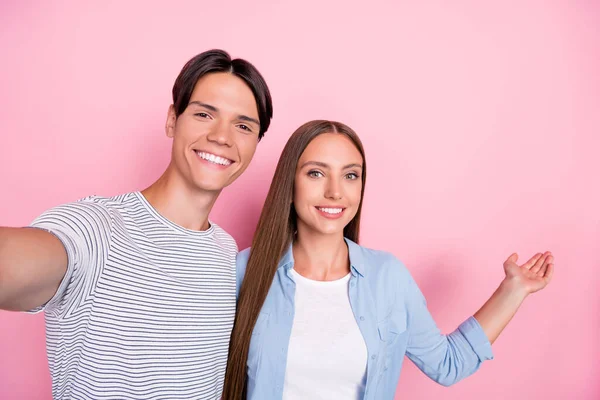 Zdjęcie słodkich sympatycznych młodych miłośników ubranych casual stroje kleszczowe selfie zapraszając najbliższych uśmiechnięty odizolowany różowy kolor tła — Zdjęcie stockowe