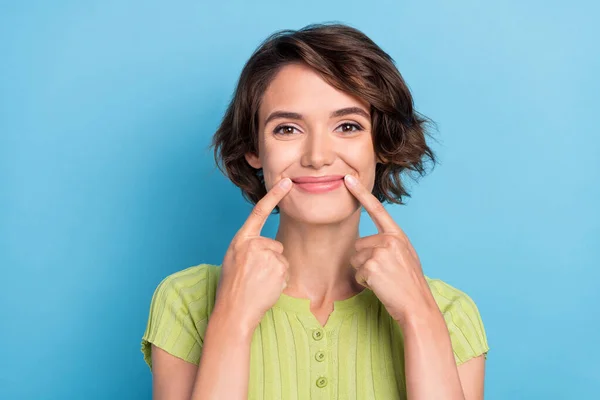 Zdjęcie atrakcyjne słodkie młoda kobieta ubrana zielony t-shirt palce usta uśmiechnięty odizolowany niebieski kolor tło — Zdjęcie stockowe