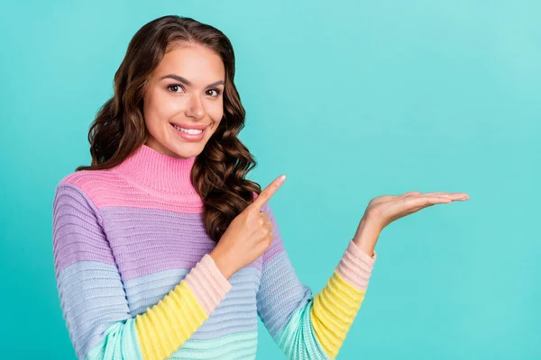 Foto di promoter bruna giovane signora indicano regalo sul braccio indossare maglione viola isolato su sfondo color verde acqua — Foto Stock