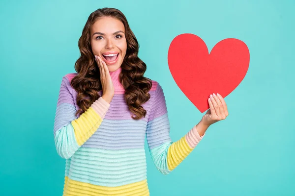 Foto von cool brünett junge Dame halten Herz Hand Gesicht Herz tragen gestreiften Pullover isoliert auf Krickente Farbhintergrund — Stockfoto