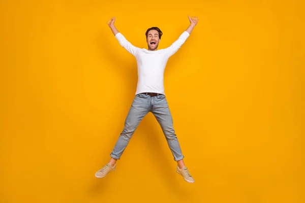 Helkroppsfoto av stor brunett ung kille hoppa bära skjorta jeans skor isolerad på gul bakgrund — Stockfoto