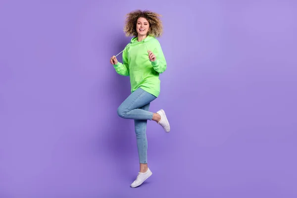 Foto de chica encantadora usan sudadera verde bailando saltando aislado color violeta fondo —  Fotos de Stock