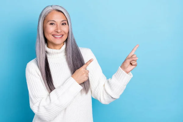 Foto della donna anziana indicano dita spazio vuoto modo diretto selezionare sconto isolato su sfondo di colore blu — Foto Stock