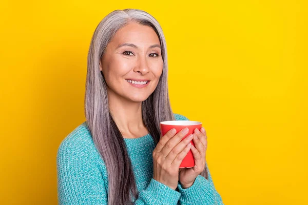 Ritratto di attraente allegra donna dai capelli grigi bere tè copia spazio isolato su sfondo di colore giallo brillante — Foto Stock
