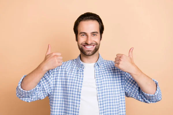 Photo de cool jeune gars montrer pouce vers le haut porter chemise à carreaux isolé sur fond de couleur beige — Photo