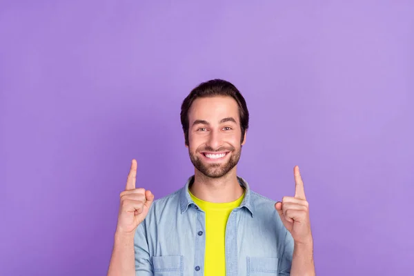 Foto de buen humor sonriente estudiante edad chico señalar los dedos hacia arriba copyspace ad promo aislado sobre fondo de color violeta —  Fotos de Stock