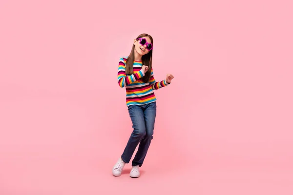 Photo of cute positive small lady enjoy clubbing wear star sunglass striped shirt isolated pink color background — Stock Photo, Image