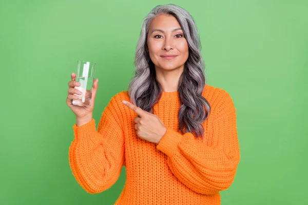 Foto di buona acconciatura grigia vecchio signora indice acqua usura maglione arancione isolato su sfondo verde — Foto Stock