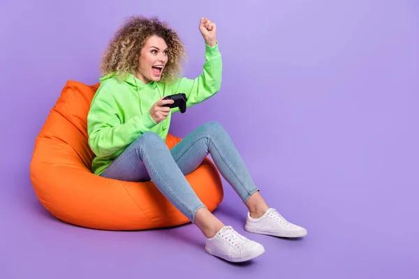 Foto av lycklig dam klädd hoodie stigande knytnäve innehav playstation tomt utrymme isolerad lila färg bakgrund — Stockfoto