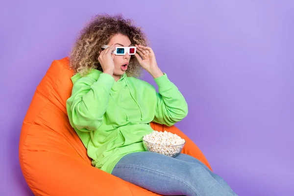 Bild av imponerad dam klädd hoodie 3d glasögon njuta popcorn tomt utrymme isolerad lila färg bakgrund — Stockfoto