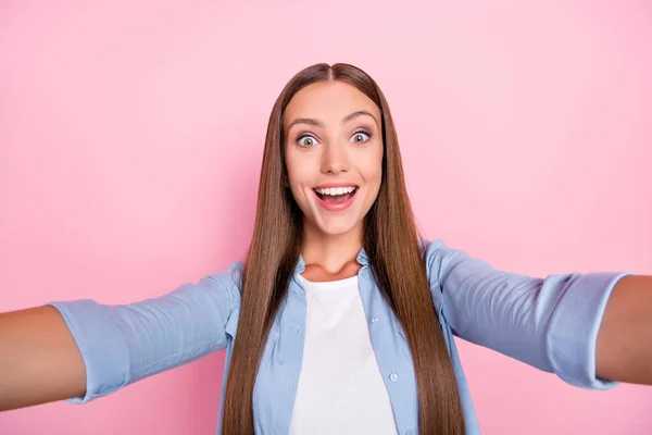 Фотографія збудженої красивої молодої леді в блакитній сорочці, що посміхається, записуючи власне відео ізольований рожевий кольоровий фон — стокове фото