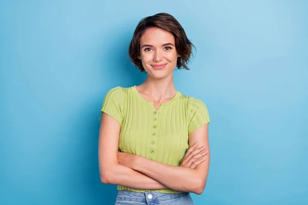 Foto de atraente confiante jovem senhora desgaste verde t-shirt sorridente braços cruzados isolado azul cor fundo — Fotografia de Stock