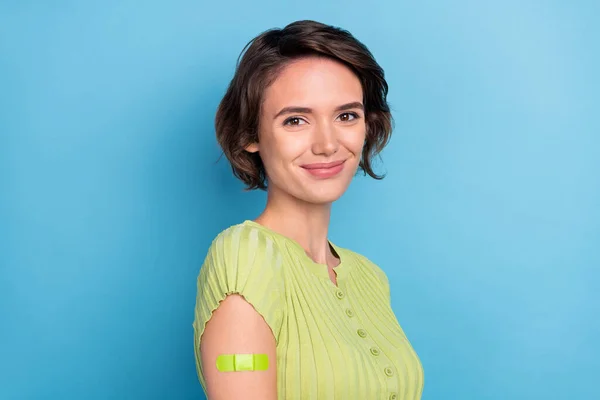 Photo de drôle adorable jeune femme porter vert t-shirt sourire vaccination fait isolé fond de couleur bleue — Photo