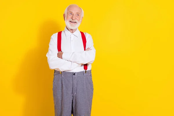 Foto do gerente envelhecido funky cabelo branco homem cruzado braços olhar espaço vazio desgaste branco camisa suspensórios isolados no fundo cor amarela — Fotografia de Stock