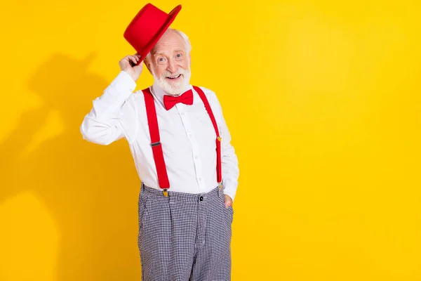 Kokuşmuş yaşlı adamın fotoğrafı. Yeni şapka, kravat, pantolon, sarı arka plan. — Stok fotoğraf