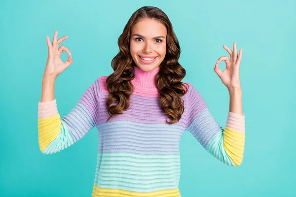Fotografie sladké brunetky tisíciletá dáma show okey nosit pruhované svetr izolované na tyrkysové barvy pozadí — Stock fotografie