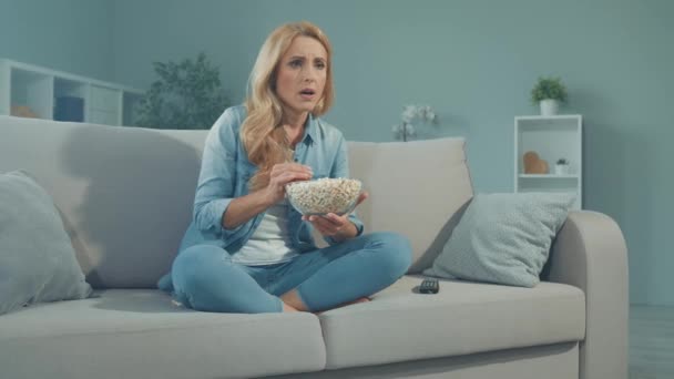 Stresszes hölgy eszik popcorn nézni intenzív szappan opera dráma film — Stock videók