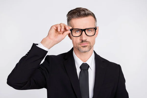Foto van ernstige slimme volwassen bediende gekleed zwart pak armbril geïsoleerde grijze kleur achtergrond — Stockfoto