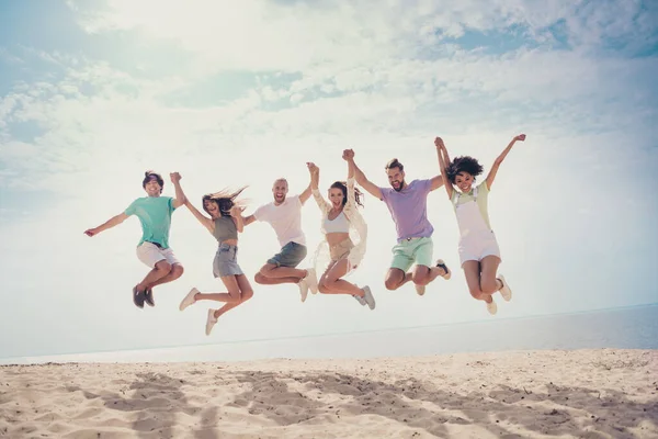 Foto de despreocupado engraçado seis jovens amigos vestidos roupas casuais andando segurando braços pulando alto sorrindo ao ar livre campo — Fotografia de Stock