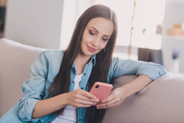 Portrét atraktivní soustředěný veselá žena sedí na pohovce pomocí zařízení gadget post smm doma — Stock fotografie