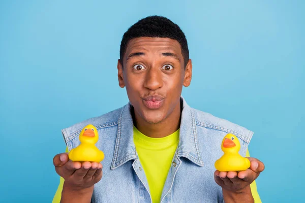 Genç afro adamın fotografı büzüşmüş dudaklar iyi ruh hali plastik oyuncak ördeği mavi arkaplanda izole edilmiş — Stok fotoğraf