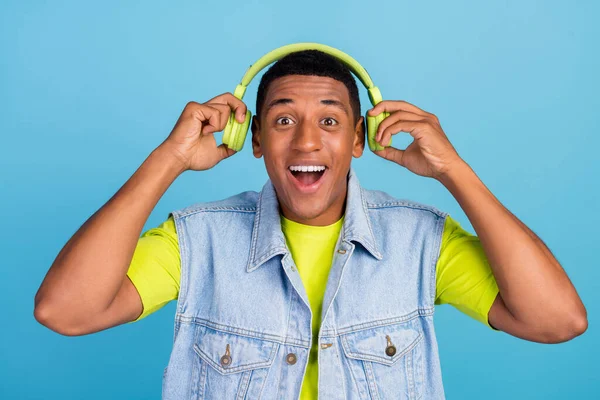 Foto de joven afro chico divertirse escuchar música auriculares radio melodía aislado sobre fondo de color azul — Foto de Stock