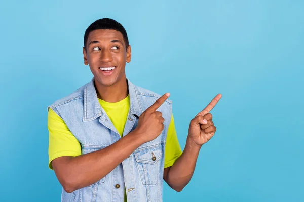 Foto de joven curioso afro hombre mirada punto dedos espacio vacío elegir decisión sugerir anuncios aislados sobre fondo de color azul —  Fotos de Stock